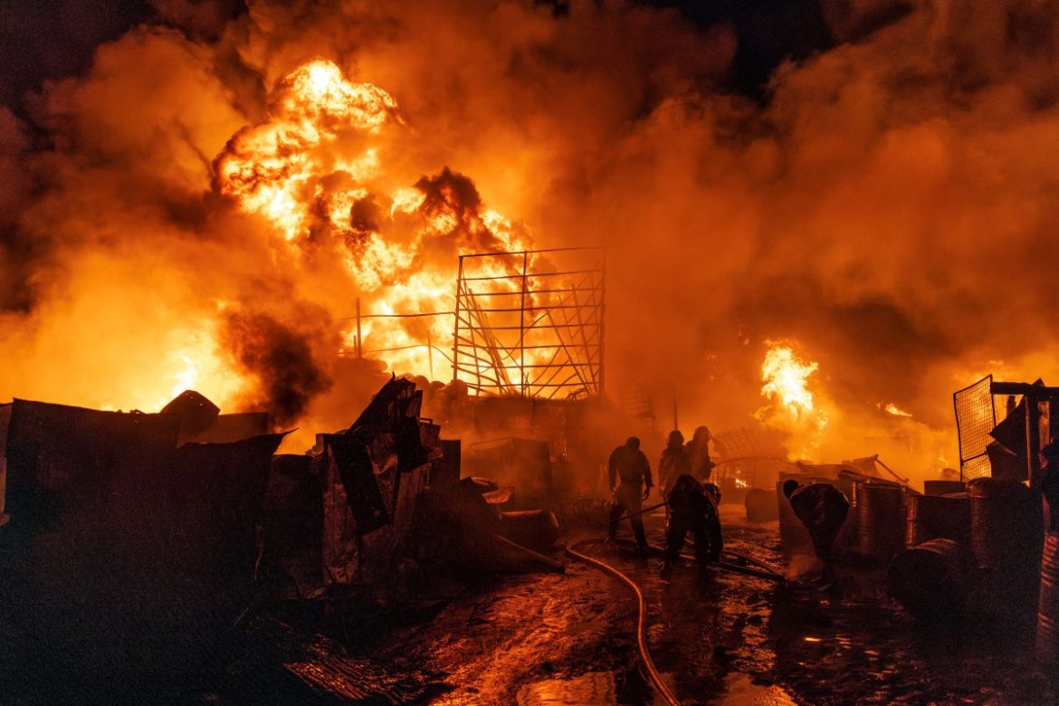 Firemen and bystanders extinguish a fire in the Makadara area of Nairobi