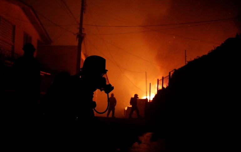 Feuerwehrleute versuchen am 2. Februar 2024, einen Brand in Viña del Mar, Chile, zu löschen. Eine riesige Rauchpilzwolke hängt über touristischen Gebieten in Zentralchile, darunter Viña del Mar und Valparaiso, wo am Freitag ein Waldbrand ausbrach. Hunderte von Häusern wurden bedroht und die Bewohner mussten evakuiert werden.  (Foto von Javier TORRES / AFP)
