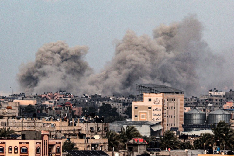 A picture taken from Rafah in the southern Gaza Strip shows smoke rising over buildings in Khan Yunis in the distance, following Israeli bombardment on February 5, 2024 as fighting continues between Israel and the Palestinian Hamas group.