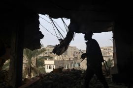 Palestinians check debris of a destroyed building in the aftermath of Israeli bombardment on Rafah in the southern Gaza Strip on February 10