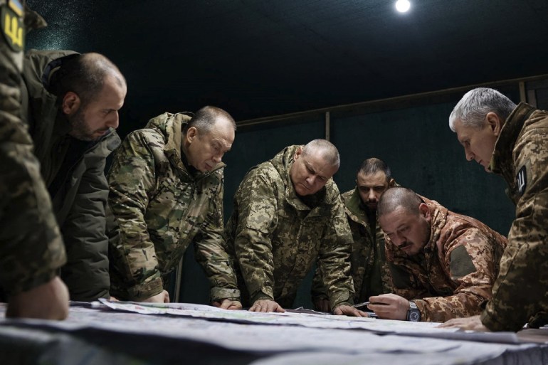 Ukraine's army chief in discussions with other senior officers near the front line in Avdiivka, They are gathered around a table looking at plans 