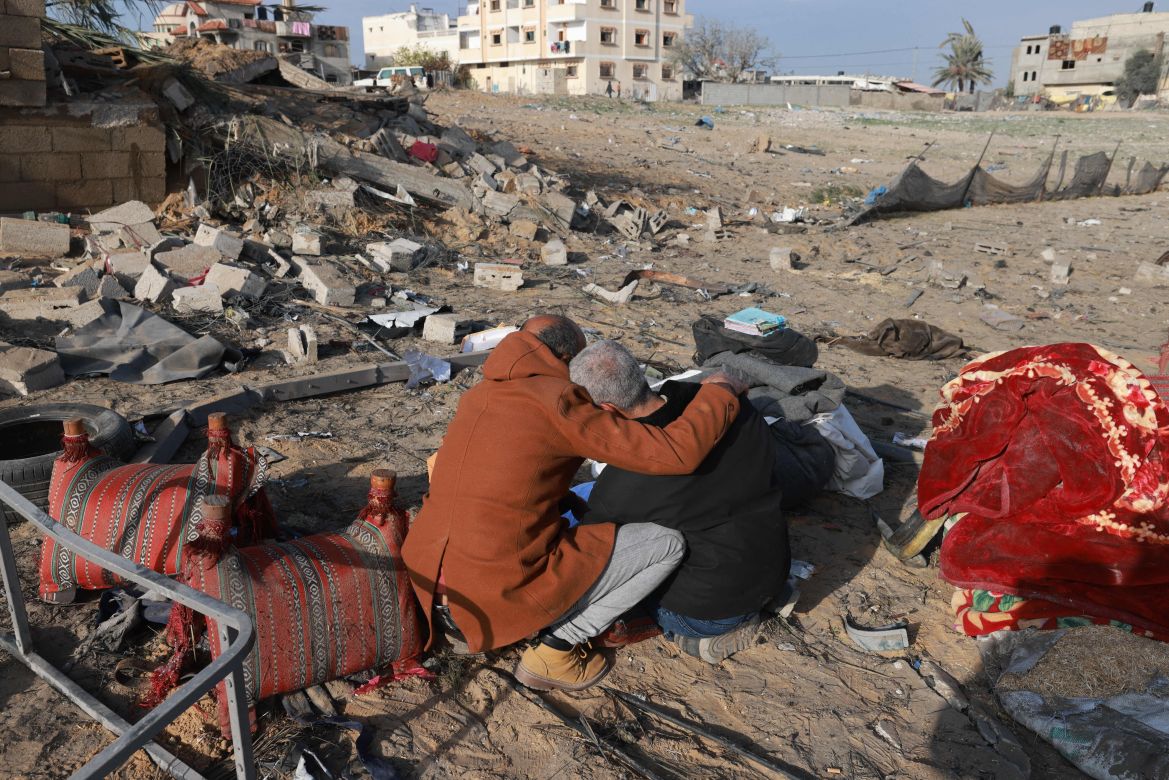 A Palestinian man comforts another as they inspect the destruction in Rafah on February 18