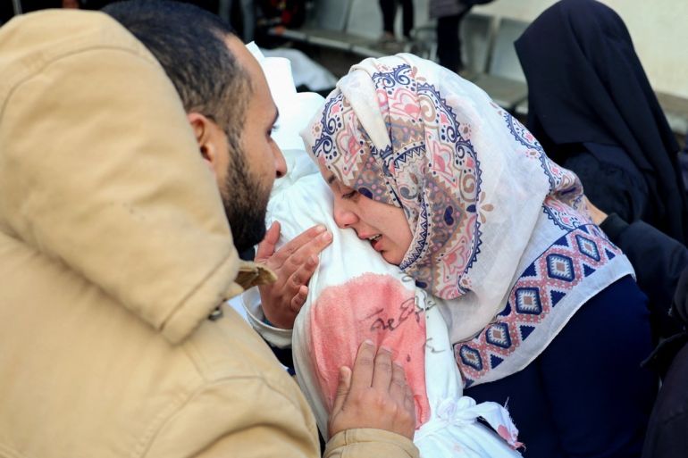A Palestinian woman mourns as she holds the body of a child at Rafah's Al-Najjar hospital