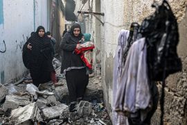 People find their way through a rubble-covered alley, following overnight Israeli bombardment in Rafah [Said Khatib/AFP]