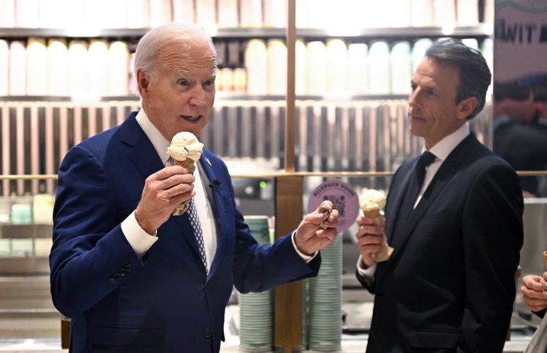 A man in a blue suit eats an ice cream