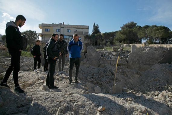 Residents and rescuers check the destruction after an overnight Israeli bombardment in the southern Lebanese village of Kafra