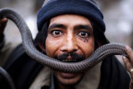 A snake charmer on the outskirts of Islamabad, Pakistan, in 2010. The practice is now banned in India and was outlawed in Pakistan by the Islamabad Wildlife Management Board in 2020 [File: Muhammed Muheisen]