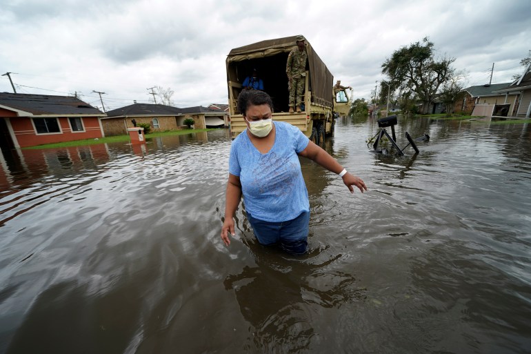 Jerilyn Collins wades through floodwaters in the aftermath of Hurricane Ida