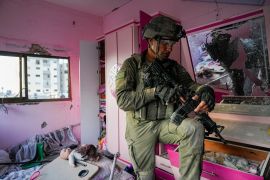 An Israeli soldier stands in an apartment during a ground operation in the Gaza Strip [Ohad Zwigenberg/AP Photo]