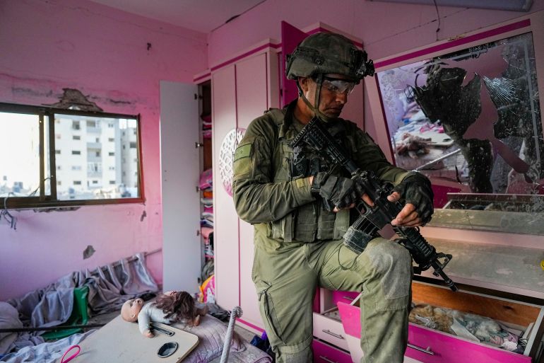 An Israeli soldier stands in an apartment during a ground operation in the Gaza Strip,