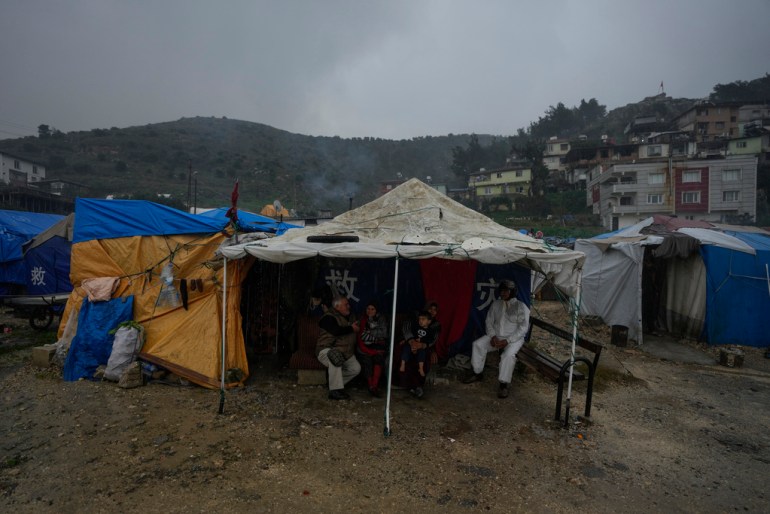 Pessoas com suas casas parcialmente destruídas durante o terremoto de fevereiro de 2023 vivem em tendas em Antakya, Turquia