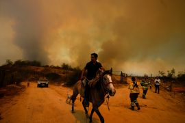 A resident flees an encroaching forest fire in Vina del Mar, Chile