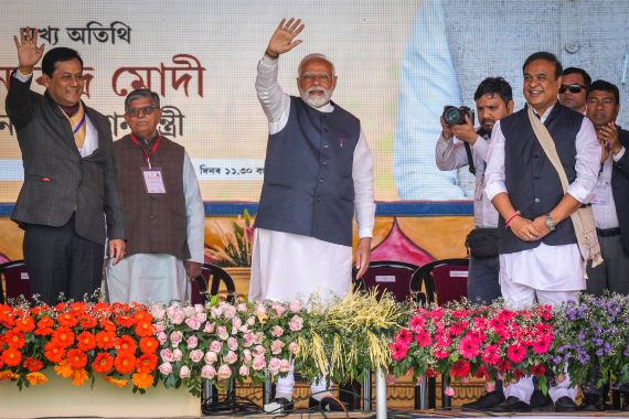 Indian Prime Minister Narendra Modi, greets the audience as he arrives with Assam Chief Minister Himanta Bishwa Sarma to address a public rally in Guwahati, India