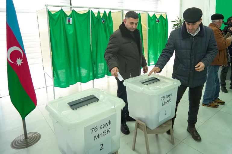 Men vote at a polling station during presidential election in Fuzuli, Karabakh region, Azerbaijan, Wednesday, Feb. 7, 2024. Azerbaijanis are voting Wednesday in an election almost certain to see incumbent President Ilhan Aliyev chosen to serve another seven-year term. (AP Photo/Sergei Grits)