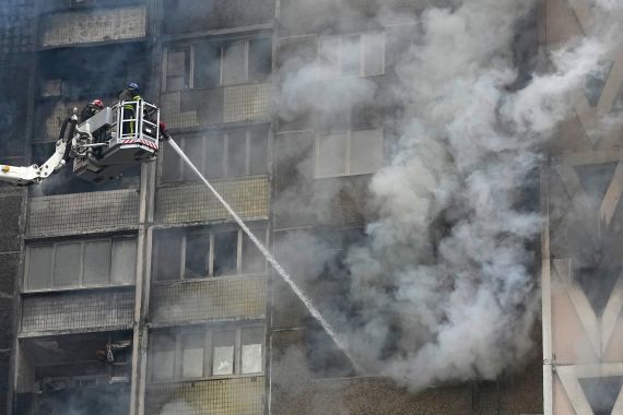 Firefighters work to extinguish a fire in an apartment building after Russian attack