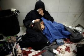 A Palestinian woman cries as she sits next to her girl wounded in the Israeli bombardment of the Gaza Strip while receiving treatment at the Nasser Hospital in Khan Younis, Southern Gaza Strip, Monday, Jan. 22, 2024. (AP Photo/Mohammed Dahman)