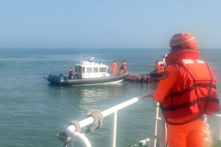 In this handout photograph provided by Taiwan Coast Guard Administration, Taiwanese coast guards inspect a vessel that capsized during a chase off the coast of Kinmen archipelago in Taiwan, Wednesday, February 14, 2024.