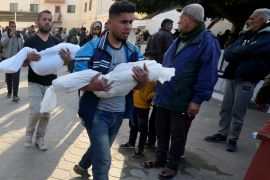 Palestinians carry the bodies of children killed in the Israeli bombardment of Gaza at the Al Aqsa Hospital in Deir el-Balah on Tuesday, February 20, 2024 [Adel Hana/AP]