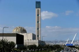 Cars drive past the Djamaa El-Djazair or the Great Mosque of Algiers [Anis Belghoul/AP Photo]