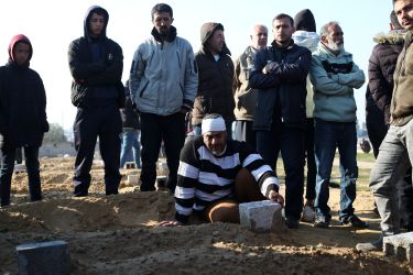 Palestinians stand around the grave of a relative killed in the Israeli bombardment of the Gaza Strip in Khan Younis