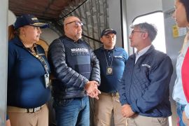 Migration officials meet former Colombian paramilitary leader Salvatore Mancuso at a gate at El Dorado international airport in Bogota, Colombia [Colombian Immigration Agency via AP]