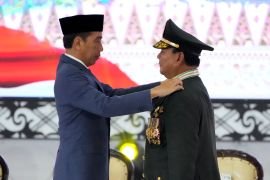 Indonesian Defence Minister Prabowo Subianto, right, receives four-star general epaulets from President Joko Widodo during a ceremony in Jakarta [Achmad Ibrahim/AP]