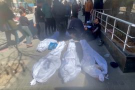 Bodies are wrapped in white shrouds on ground outside Shifa Hospital in Gaza City. Israeli troops fired on a crowd of Palestinians waiting for aid in Gaza City on Thursday, witnesses said. [AP Photo]