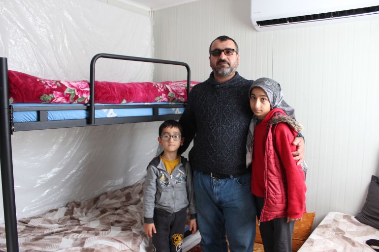 Ahmet Firat, centre, with Emir (7), and Havvanur (11) in the kids' bedroom in the family's container, Beni, Turkey
