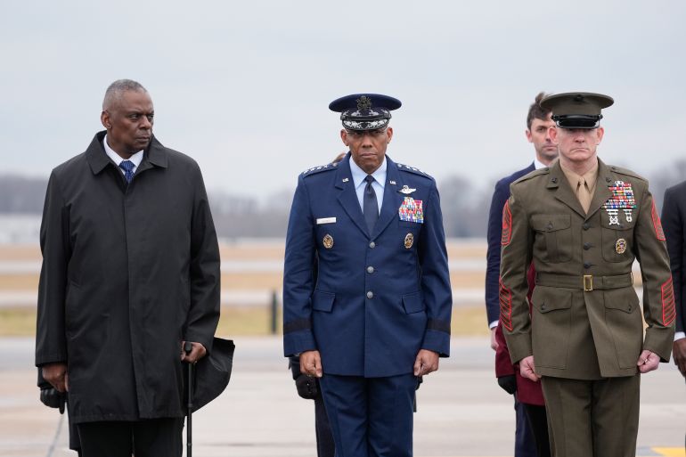 US military chiefs watch as coffins containing the remains of three soldiers killed in Jordan return to the Dover Air Force Base, Delaware