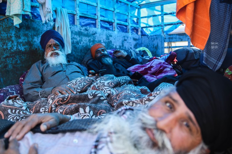 Farmers resting in a tractor trolley at the protest site on the Shambhu border between the Indian states of Haryana and Punjab [Md Meherban/Al Jazeera]