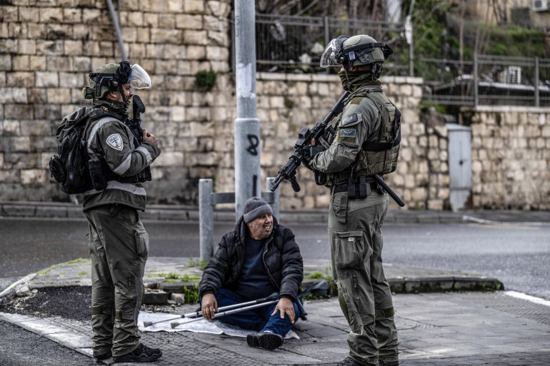 A handicapped Palestinian attempts to pray at the street while Israeli forces take security measures as restriction on Palestinian worshipers' access to Al-Aqsa Mosque for Friday prayers continues