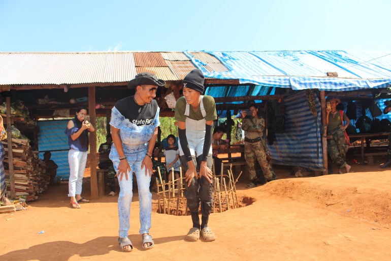 Deux soldats de la KTLA vêtus de vêtements donnés par leurs supporters exécutent une danse comique pour le plus grand plaisir de leurs camarades dans leur camp (Lorcan Lovett/Al Jazeera)