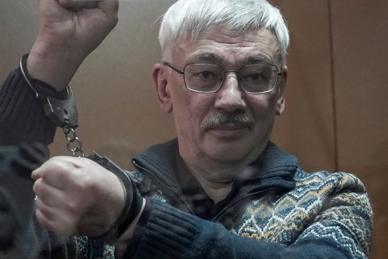 Oleg Orlov with handcuffs.