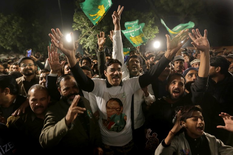 PMLN supporters dance at the party's Lahore headquarters on Friday. [Rahat Dar/EPA]