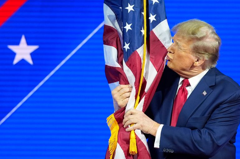 Trump kisses the flag of the United States.