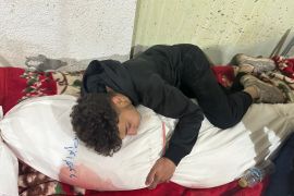 Ahmed curled up, holding the shrouded bloodied body of his mother