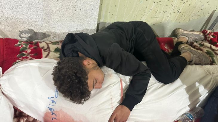 Ahmed curled up, holding the shrouded bloodied body of his mother