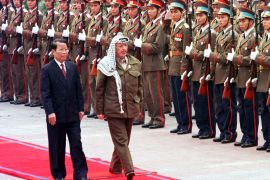 Palestinian President Yasser Arafat inspects an honour guard with Vietnamese President Tran Duc Luong in Hanoi in 1999 [File: AFP]