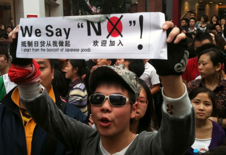 Ein Demonstrant mit einem Transparent ruft Parolen während eines Anti-Japan-Protestes über die umstrittenen Inseln Diaoyu in China und Senkaku in Japan vor einem japanischen Einkaufszentrum Ito Yokado im Geschäftsviertel Chunxi Road in Chengdu am 16. Oktober 2010. Tausende Chinesen gingen am Samstag in mehreren Städten auf die Straße, um Chinas Souveränitätsrechte angesichts des jüngsten Streits mit Japan um die Diaoyu-Inseln zu verteidigen.  Xinhua-Reporter waren Zeugen von Demonstrationen in Xi'an, Chengdu, Hangzhou und Zhengzhou auf dem chinesischen Festland.  REUTERS/Jason Lee (CHINA - Tags: POLITISCHE UNRUHEN)