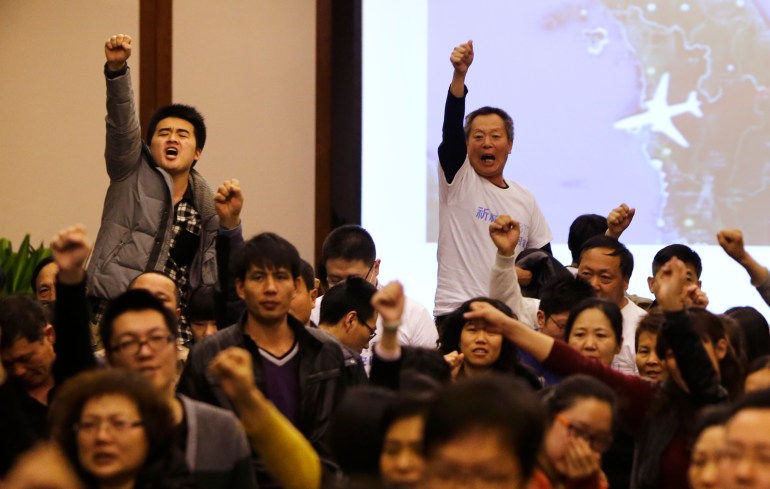 Family members of the Chinese passengers on board MH370 show their anger at a meeting with the airline