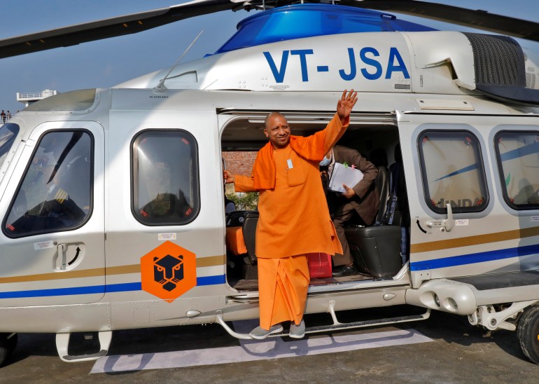 Yogi Adityanath, Chief Minister of the northern state of Uttar Pradesh, waves to his party supporters as he disembarks from a helicopter to attend an election campaign rally in Sambhal district of the northern state, India, February 10, 2022. REUTERS/Pawan Kumar
