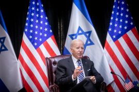 Joe Biden with Israeli and US flags behind him