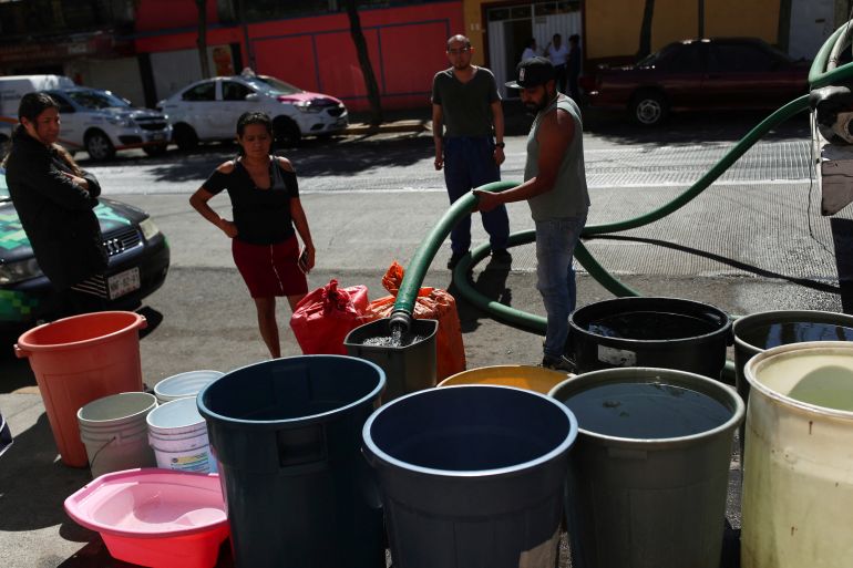 People fill buckets with water from a water tanker truck in the Azcapotzalco neighborhood, as tensions over water scarcity in Mexico City, one of Latin America's largest capitals, are boiling over as residents in some neighborhoods protest weeks-long dry spells in their homes, in Mexico City, Mexico January 26, 2024