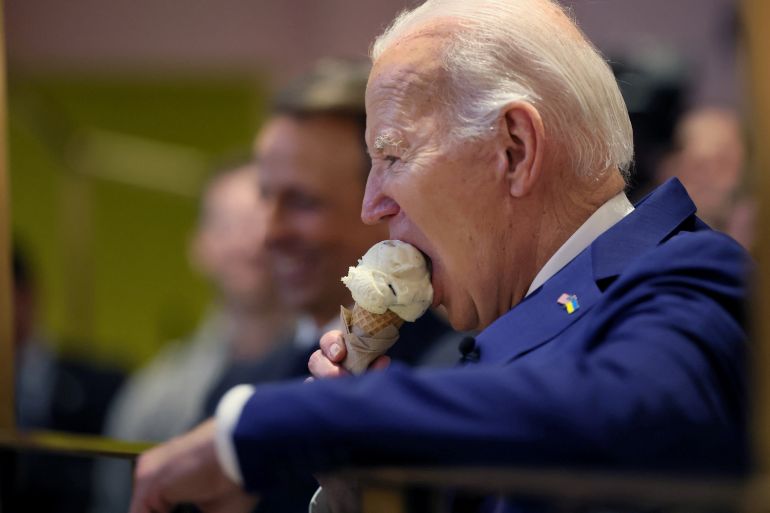 U.S. President Joe Biden bites into his ice cream as he and Seth Meyers visit Van Leeuwen Ice Cream in downtown New York, U.S. February 26, 2024. REUTERS/Leah Millis