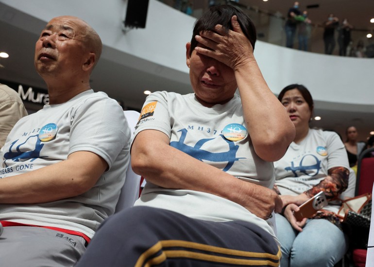 Un familiar del vuelo MH370 desaparecido de Malaysia Airlines reacciona durante una ceremonia de conmemoración del décimo aniversario de su desaparición