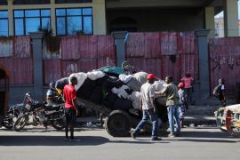 Haitians gather their belongings as they prepare to flee their homes following a surge in violence in the capital Port-au-Prince on March 3 [Ralph Tedy Erol/Reuters]