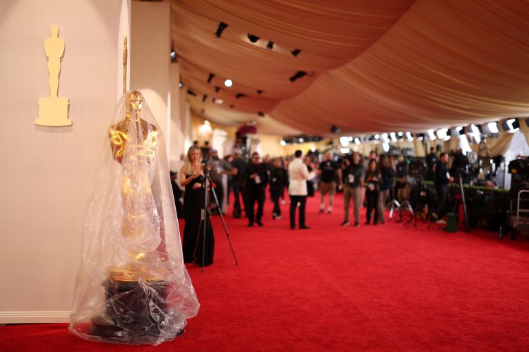 An Oscar statue is covered in plastic as preparations continue for the 96th Academy Awards in Los Angeles