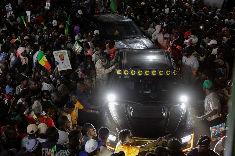 Supporters surround the car of Senegalese opposition leader Ousmane Sonko, who was released from prison along with the presidential candidate he is backing in the March 24 election, Bassirou Diomaye Faye, in Dakar, Senegal March 15, 2024.REUTERS/Zohra Bensemra