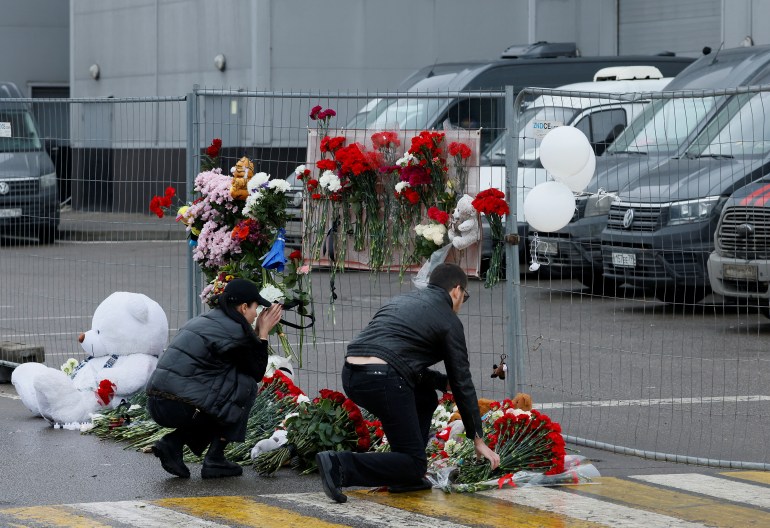 İnsanlar, 23 Mart Rusya'nın Moskova Bölgesi'ndeki Crocus Belediye Binası konser salonunda düzenlenen silahlı saldırının kurbanları için yapılan derme çatma anıta çiçek bıraktı.