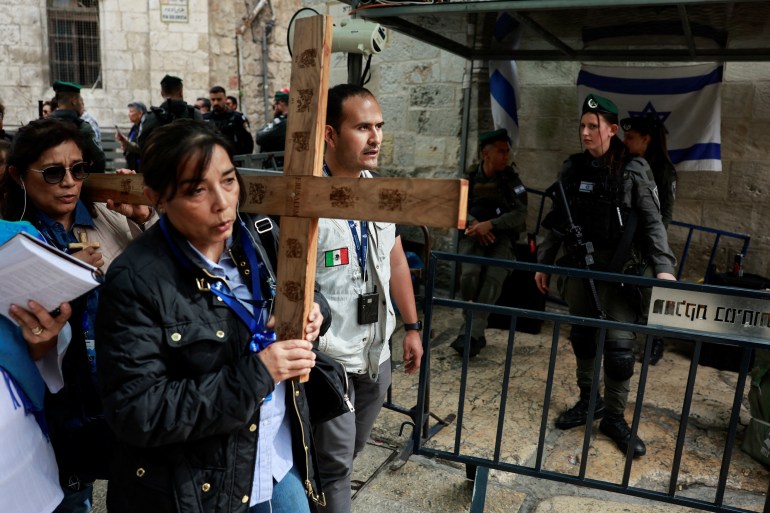 Les fidèles portent une croix alors qu'ils participent à la procession du Vendredi Saint sur la Via Dolorosa dans la vieille ville de Jérusalem